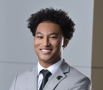 man with hat on smiling for headshot photo