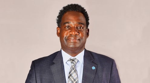 brown man in suite smiling for headshot photo